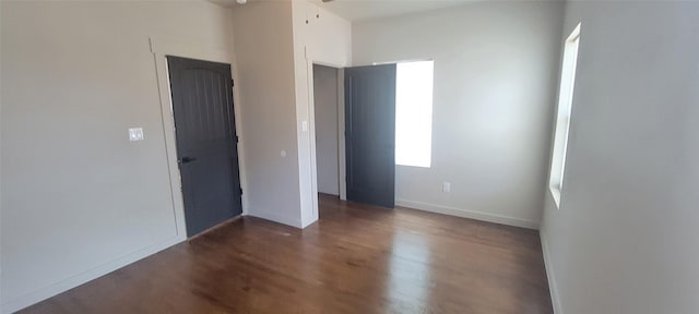 empty room with wood finished floors, baseboards, and a ceiling fan