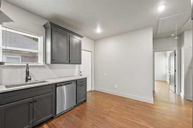 2735 S Jennings Ave, Fort Worth, TX 76110 - kitchen with stainless steel dishwasher, a sink, decorative backsplash, light wood finished floors, and baseboards