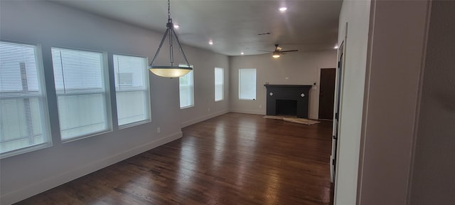 unfurnished living room featuring a fireplace with flush hearth, baseboards, dark wood-type flooring, a ceiling fan, and recessed lighting