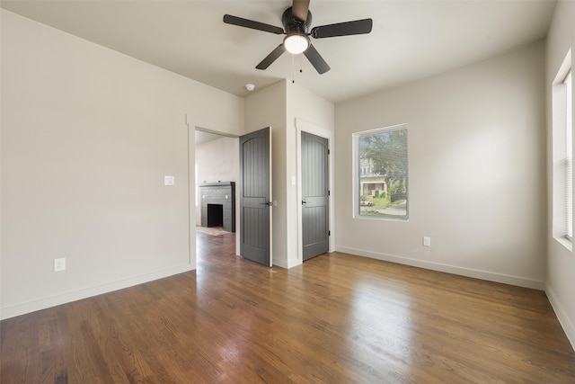 2735 S Jennings Ave, Fort Worth, TX 76110 - unfurnished bedroom with baseboards, wood finished floors, a fireplace, and ceiling fan