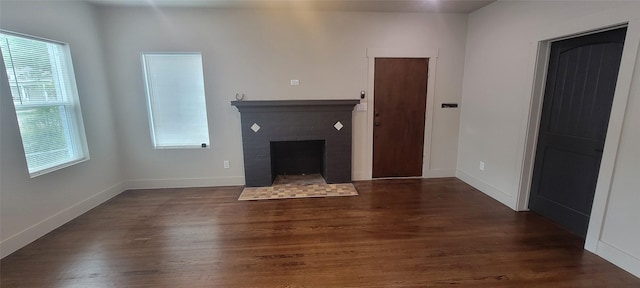 unfurnished living room featuring wood finished floors, a fireplace, and baseboards