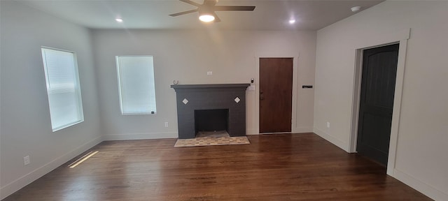 unfurnished living room with a ceiling fan, wood finished floors, a fireplace, and baseboards