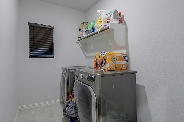 laundry area with washer and dryer and baseboards