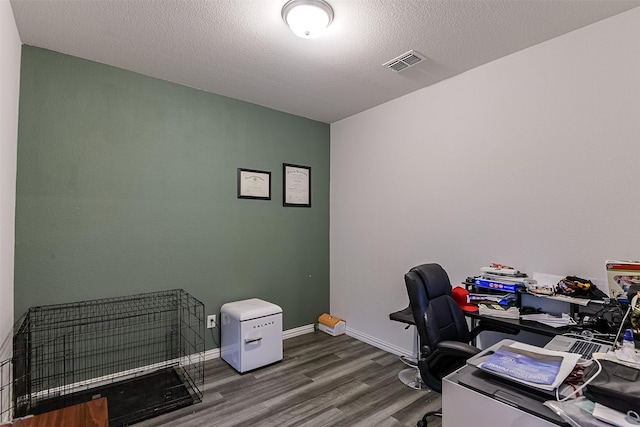 office space featuring wood finished floors, baseboards, and a textured ceiling