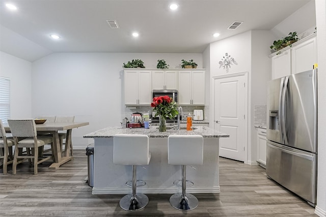 kitchen featuring stainless steel appliances, a sink, tasteful backsplash, white cabinets, and recessed lighting