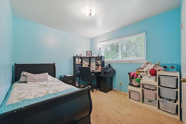 bedroom featuring carpet, an office area, and baseboards