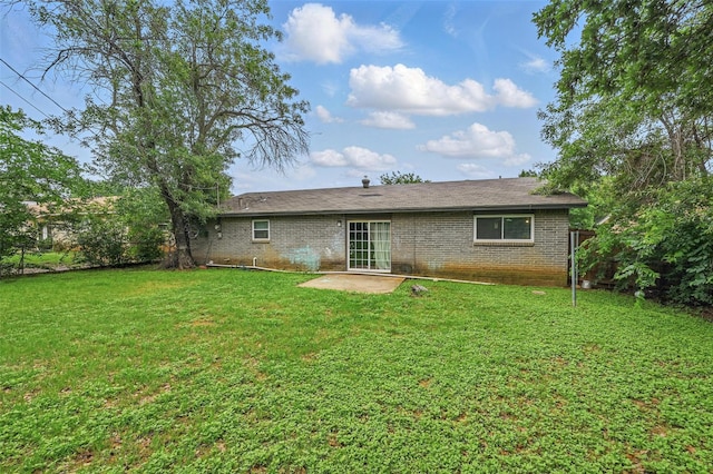 back of house featuring brick siding, a patio area, and a lawn