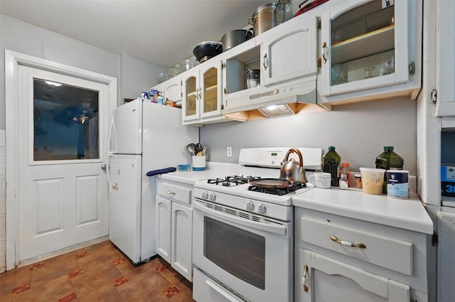 kitchen with white appliances, under cabinet range hood, glass insert cabinets, and light countertops