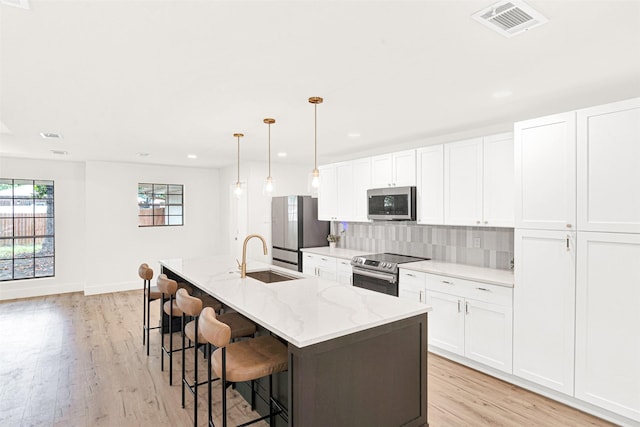 303 Randy Lee Ln, Mckinney, TX 75071 - kitchen with appliances with stainless steel finishes, a sink, light wood-type flooring, white cabinets, and recessed lighting
