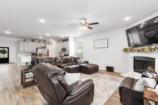 804 Feather Edge Dr, Springtown, TX 76082 - living area featuring a ceiling fan, a fireplace with raised hearth, light wood finished floors, recessed lighting, and baseboards