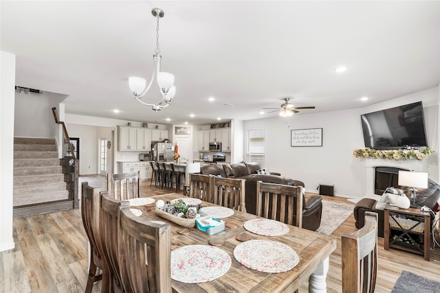 804 Feather Edge Dr, Springtown, TX 76082 - dining space featuring light wood-style flooring, a ceiling fan, a chandelier, stairs, and recessed lighting