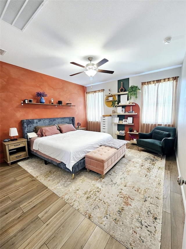 3405 Western Trl, Crandall, TX 75114 - bedroom featuring wood finished floors, a ceiling fan, and an accent wall