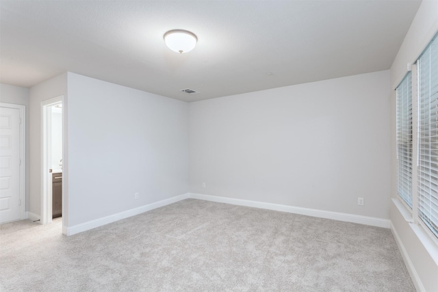 unfurnished bedroom featuring light colored carpet and baseboards