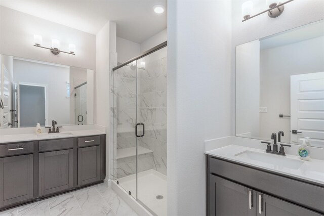 bathroom featuring a marble finish shower, marble finish flooring, and two vanities