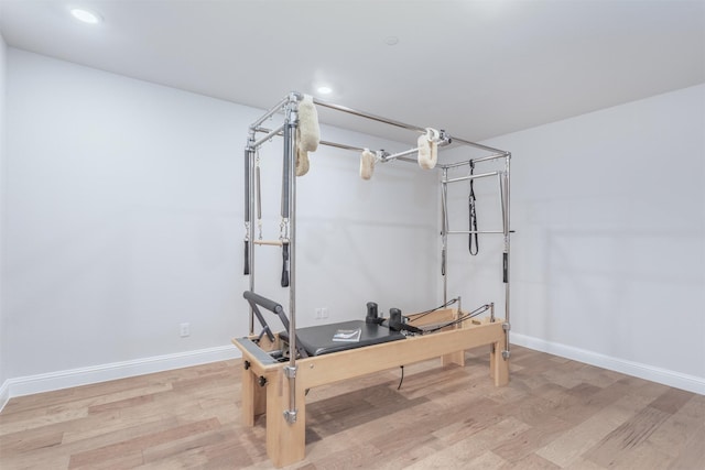 workout room featuring wood finished floors, baseboards, and recessed lighting