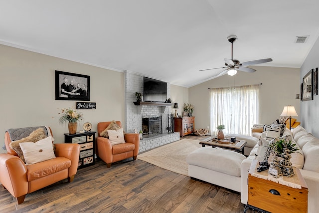 living area featuring a ceiling fan, dark wood-style flooring, a fireplace, lofted ceiling, and crown molding