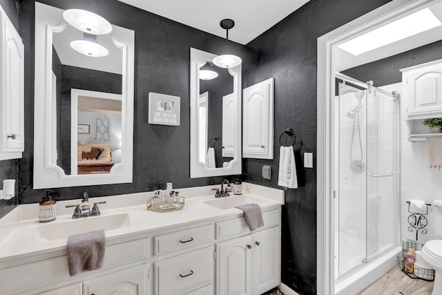 bathroom featuring a shower stall and double vanity