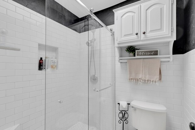 full bathroom featuring a stall shower, toilet, and tile walls