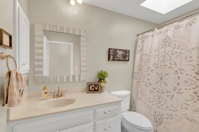 bathroom featuring a skylight, toilet, and vanity