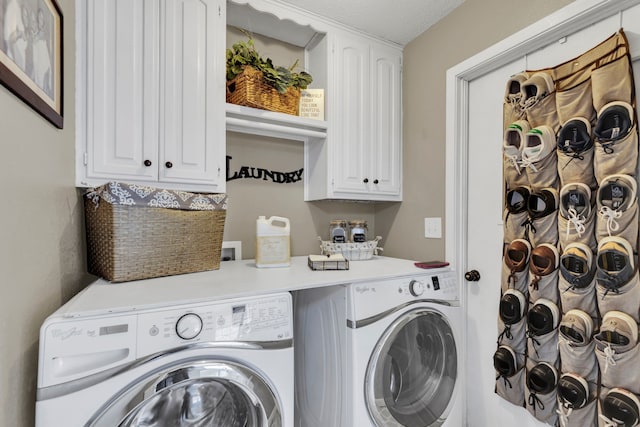 laundry room featuring washing machine and clothes dryer and cabinet space