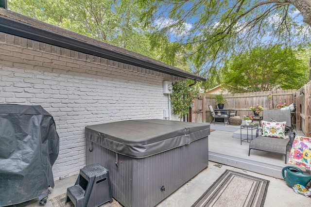 deck featuring a hot tub and a fenced backyard