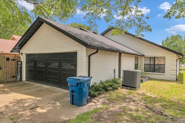 view of home's exterior with central AC unit, brick siding, roof with shingles, and a garage