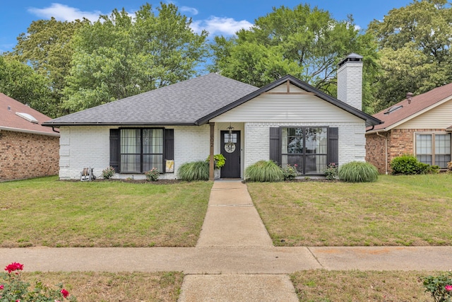 view of front of house featuring brick siding, a front yard, and roof with shingles