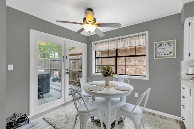 dining area featuring light wood-type flooring, ceiling fan, baseboards, crown molding, and french doors