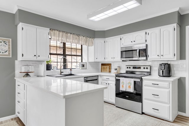 kitchen featuring appliances with stainless steel finishes, a peninsula, ornamental molding, white cabinets, and tasteful backsplash