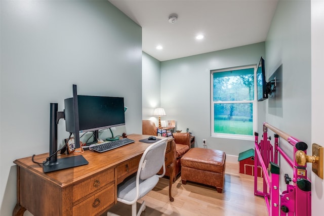 office with light wood-type flooring and recessed lighting