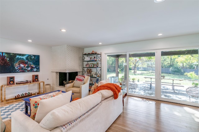 living area featuring recessed lighting, a large fireplace, and light wood finished floors