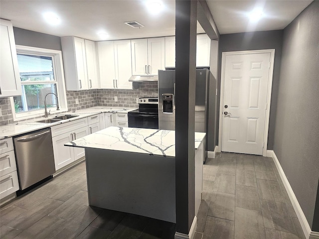 6604 Tabor St, North Richland Hills, TX 76180 - kitchen featuring appliances with stainless steel finishes, a sink, wood finished floors, backsplash, and under cabinet range hood