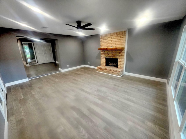 6604 Tabor St, North Richland Hills, TX 76180 - unfurnished living room featuring ceiling fan, a fireplace, wood finished floors, and baseboards