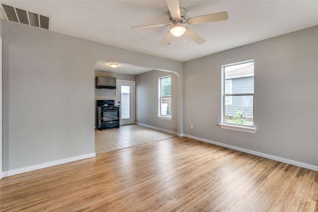 2524 Malvern Trl, Fort Worth, TX 76105 - empty room featuring arched walkways, light wood-style flooring, and baseboards