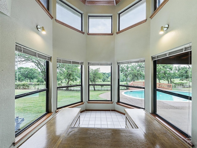 unfurnished sunroom with a towering ceiling and tile patterned flooring