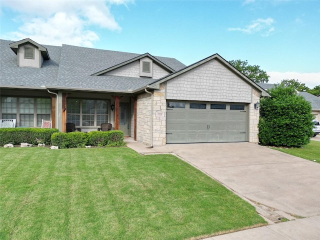 ranch-style home with roof with shingles, an attached garage, concrete driveway, and a front lawn