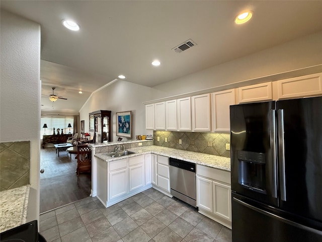 kitchen featuring black refrigerator with ice dispenser, stainless steel dishwasher, a sink, ceiling fan, and vaulted ceiling