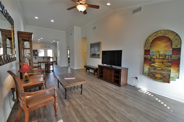 living area featuring a ceiling fan, ornamental molding, wood finished floors, baseboards, and recessed lighting