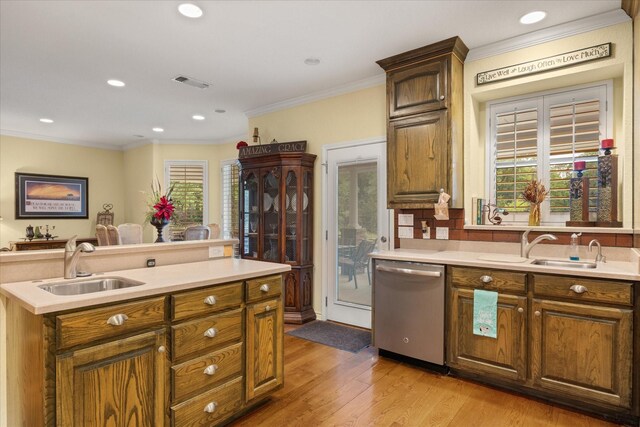 kitchen with stainless steel dishwasher, a sink, ornamental molding, light countertops, and light wood-style flooring