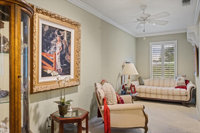 living area with crown molding, carpet floors, ceiling fan, and baseboards