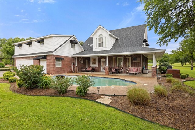 rear view of property featuring brick siding, a lawn, a patio area, an attached garage, and a shingled roof