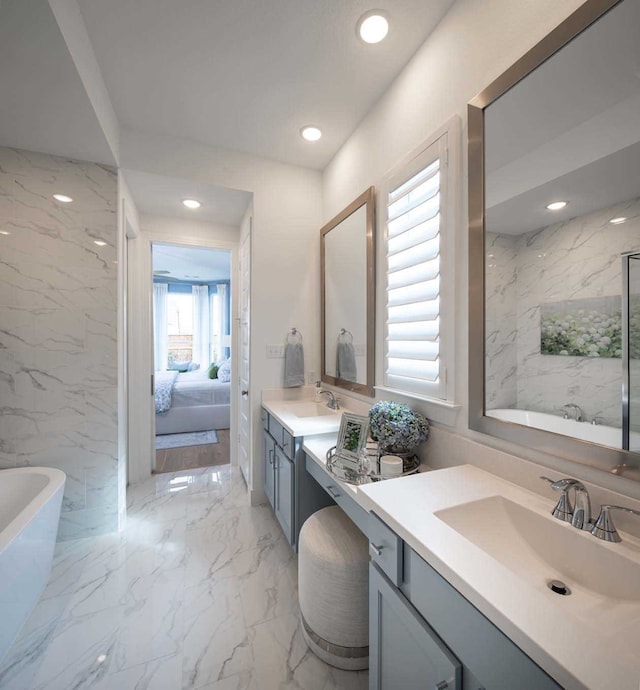2210 Desmond Dr, Forney, TX 75126 - full bathroom featuring a freestanding tub, ensuite bathroom, two vanities, recessed lighting, and tile walls