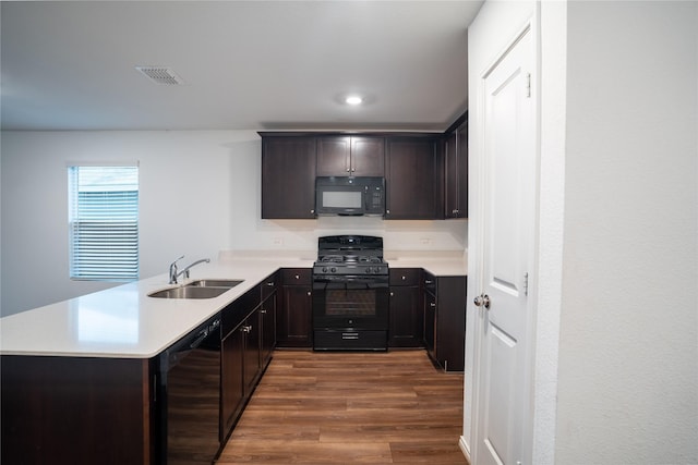 2923 Cascade Ln, Forney, TX 75126 - kitchen featuring a sink, black appliances, wood finished floors, a peninsula, and light countertops