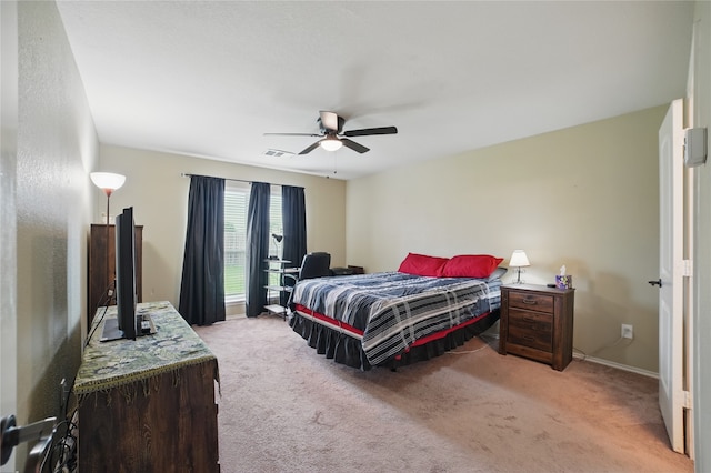 bedroom with light colored carpet, ceiling fan, and baseboards