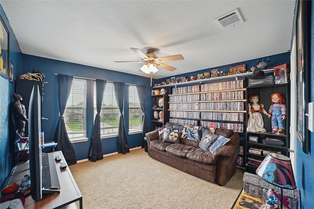 living room featuring carpet, ceiling fan, a textured ceiling, and baseboards