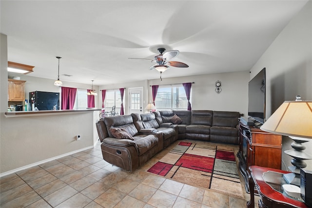 living area featuring ceiling fan, baseboards, and light tile patterned flooring