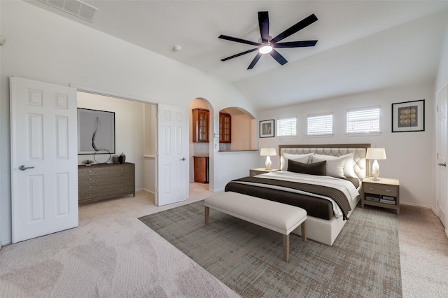 carpeted bedroom with arched walkways, lofted ceiling, baseboards, and a ceiling fan