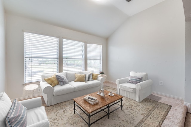living room with lofted ceiling, carpet floors, and baseboards