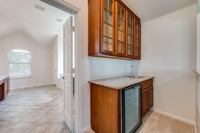indoor wet bar featuring lofted ceiling and wine cooler