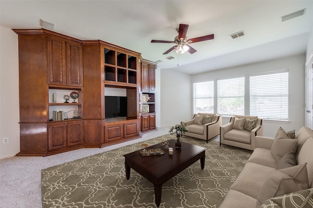 carpeted living room with ceiling fan, baseboards, and lofted ceiling